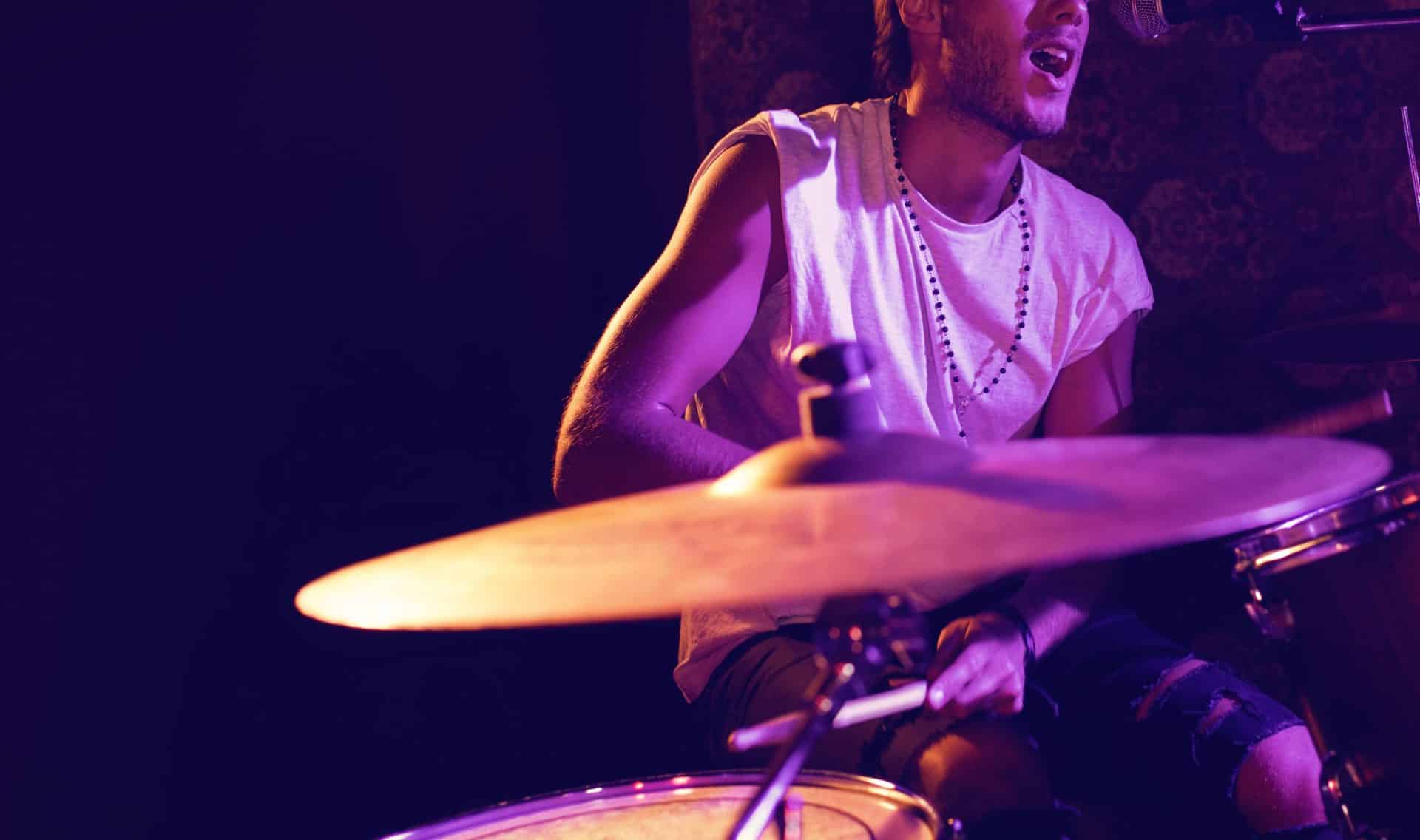 Singer Playing Drums While Performing In Nightclub